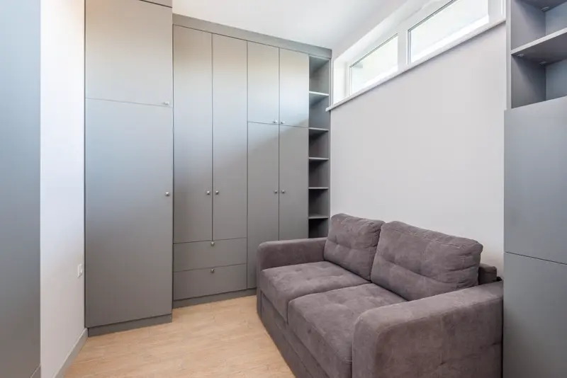 Compact grey sofa bed in a small apartment-style room